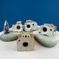 Christmas Village Collection of Small Illuminated Houses. Set of 4 Bldgs: Mill, 2 Churches, Train St., Council Offices, 2 Sheep and 3 Pines.